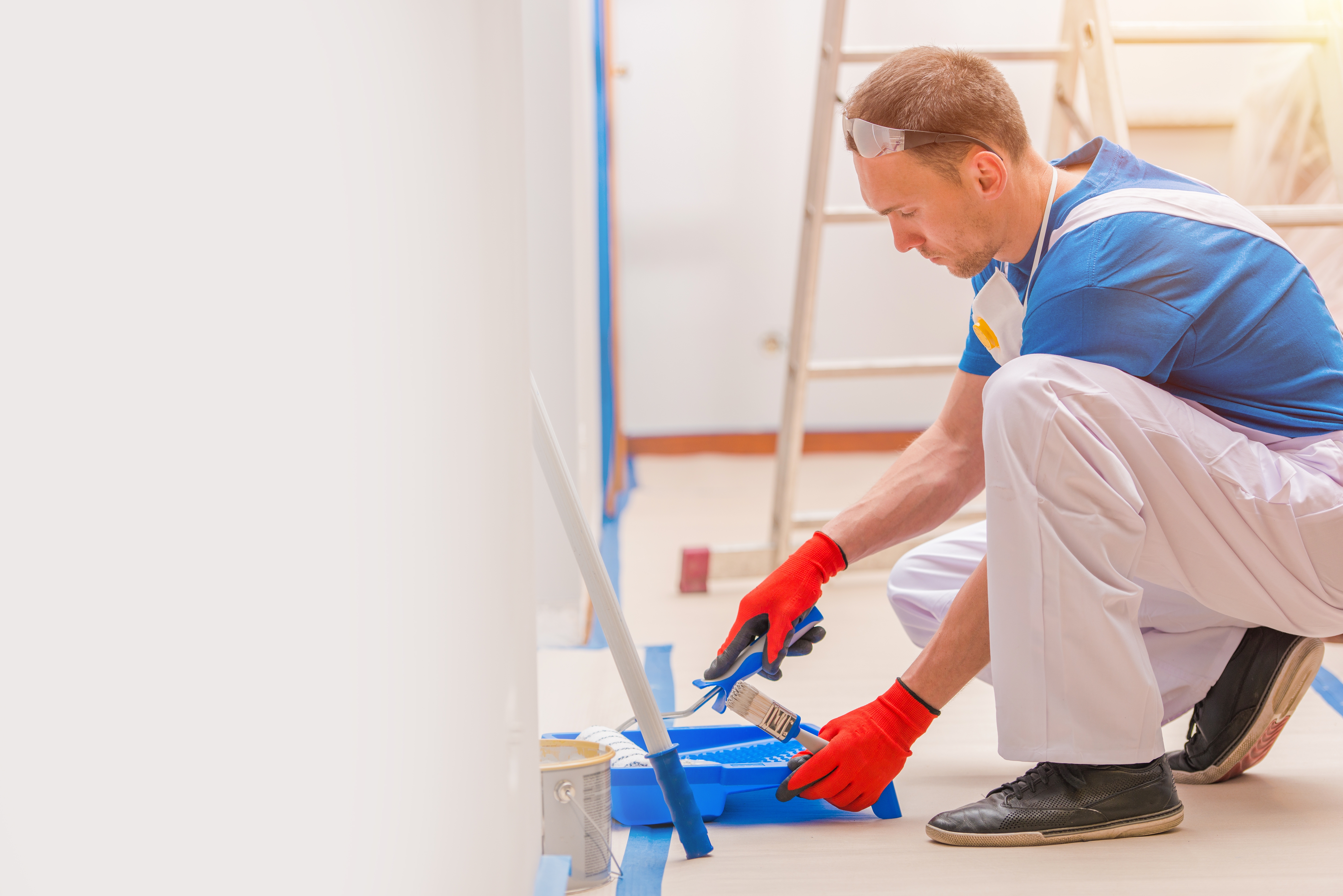 House Walls Painting. Young Caucasian Men Painting His Home. Construction and Renovation.