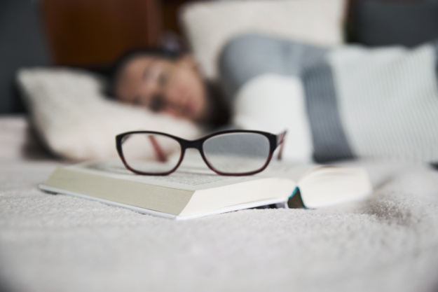 glasses-and-book-near-sleeping-woman_23-2147767347